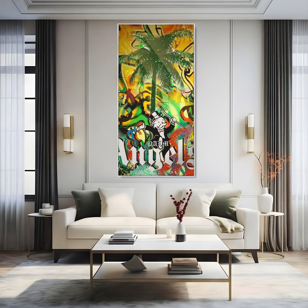 Tablou canvas cu tablou canvas cu graffiti monopoly si palmier, in rama de aluminiu argintiu, pe perete intr-un living